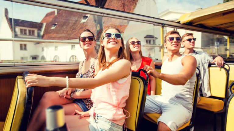 People smiling on an open top bus